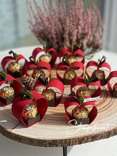 there are many heart shaped candies on the wooden platter with flowers in the background