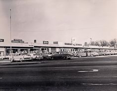 an old black and white photo of cars parked in front of a gas station