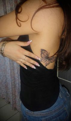 a woman with tattoos on her upper back