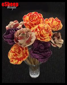 a vase filled with flowers on top of a black table next to a dark background