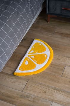 a yellow and white rug on the floor with a slice of orange in it's center