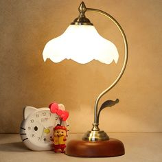 a hello kitty lamp next to an alarm clock on a table with a hello kitty figurine