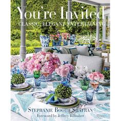 a table with flowers and plates on it in front of an outdoor dining room area