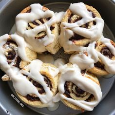 several cinnamon rolls with icing in a pan