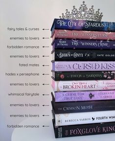 a stack of books sitting on top of each other next to a wall with the names of different authors