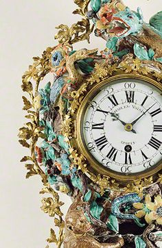 an ornate clock with birds and flowers on it's face is shown against a white background