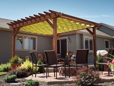 an outdoor patio with chairs and table under a yellow awning over the dining area