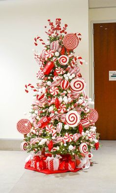 a christmas tree decorated with red and white candies, lollipops and candy canes