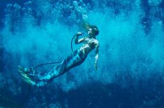 a woman is swimming in the water with a hose attached to her waist and head