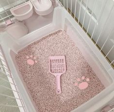 a pink brush in a white cage with footprints on the floor