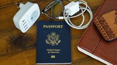 a passport, power strip and charger on a wooden table