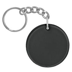 a black round key chain with a metal ring around it's end and an oval tag on the front