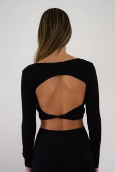 Black long sleeve, crop top. Open back with knot detail across the back. Tori is wearing a size small. Open Back Black Top, Elegant Black Backless Crop Top, Black Stretch Backless Crop Top, Black Seamless Backless Crop Top, Open Back Tops, Black Stretch Crop Top With Hollow Details, Black Long Sleeve Crop Top, Long Sleeve Crop, Black Long Sleeve