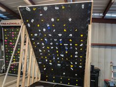 there is a climbing wall in the garage that has been constructed into a structure for people to climb on