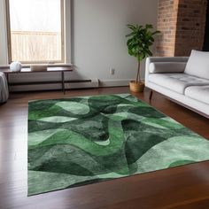 a living room with white couches and a green area rug on the wooden floor