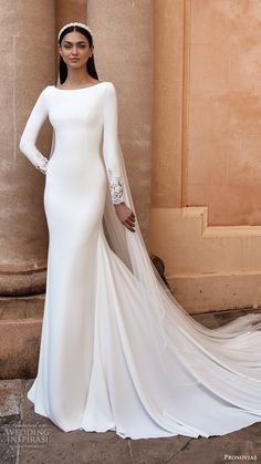 a woman in a white wedding dress standing next to a pillar wearing a tiara and veil