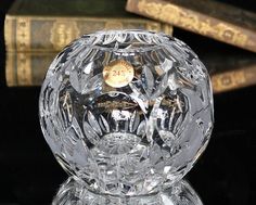 a crystal ball with a clock on it sitting in front of some books and an old book