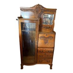 an antique wooden armoire with mirror on top