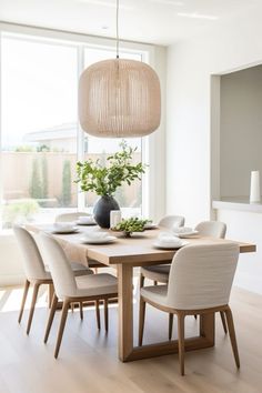 a dining room table with chairs and a vase on it