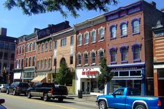 several cars are parked on the street in front of buildings