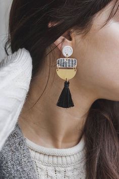 a close up of a person wearing some kind of earring with tassels