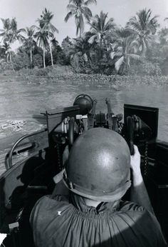 a black and white photo of a man in a boat looking out at the water