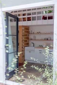 an open door leading into a kitchen with lots of counter space and cupboards on the wall