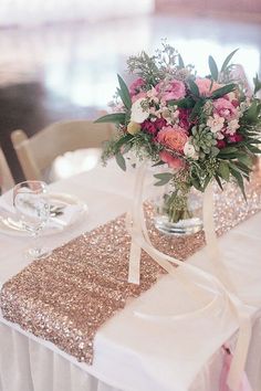 a vase filled with flowers sitting on top of a table next to a white table cloth