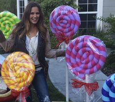 a woman standing in front of some lollipops