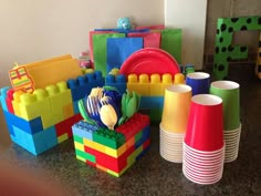 there are many legos and cups on the table