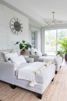 a living room filled with furniture and a large clock mounted to the wall above it