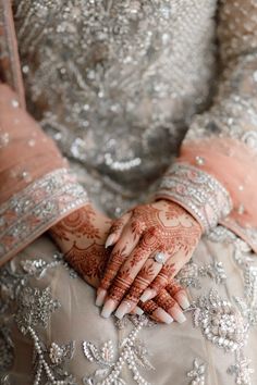 a woman's hands with hennap on her arm and the other hand