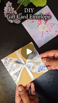 someone is holding an origami card envelope with flowers on it and the words diy gift card envelope