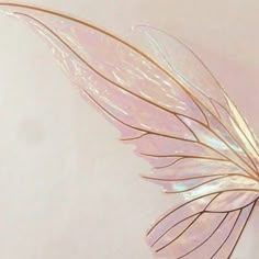 a close up of a leaf shaped object on a white surface with light pink background