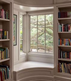 a curved window with bookshelves in the corner