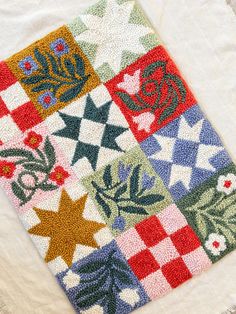 a multicolored patchwork quilt with stars and flowers on it's side