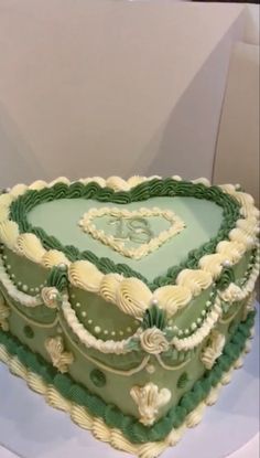 a large heart shaped cake with green frosting