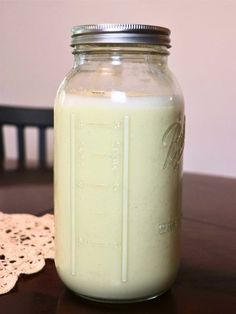 a glass jar filled with milk sitting on top of a table