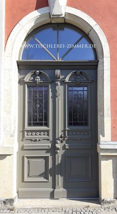 the front entrance to an old building with two double doors