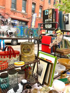 there are many different items on the table in front of the store window and one is for sale