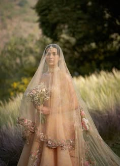 a woman in a wedding dress with flowers on her veil