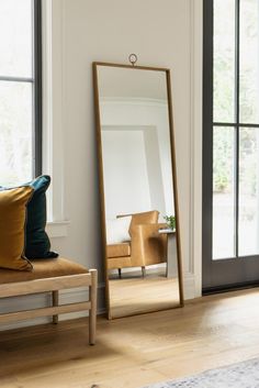 a large mirror sitting on top of a wooden floor