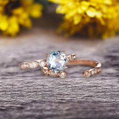 an engagement ring with a blue topazte surrounded by white and brown diamonds on a wooden surface