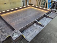 a large wooden table with drawers and lights on the top, in a shop area