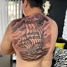 a man with a ship tattoo on his back