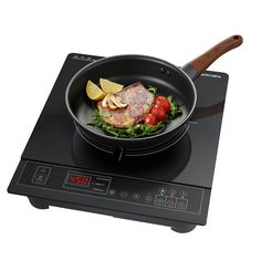 a frying pan filled with meat and vegetables on top of an electric cooktop