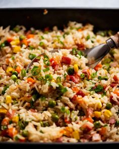 a pan filled with rice and vegetables on top of a table