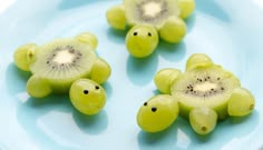 grapes and kiwis on a blue plate with one cut in the shape of a turtle