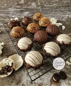 chocolate covered cookies and marshmallows sit on a cooling rack next to an oreo cookie