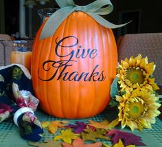 a large pumpkin sitting on top of a table next to sunflowers and candles